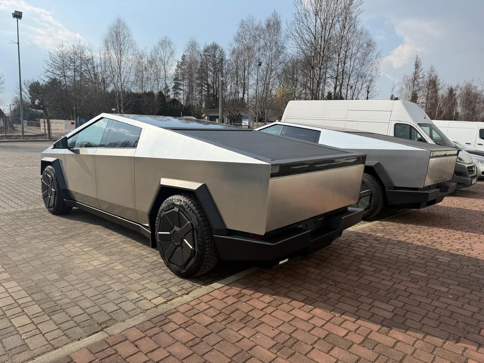 Dwa egzemplarze Tesla Cybertruck na parkingu firmowym