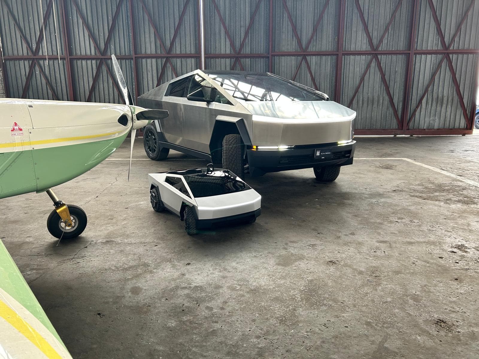Tesla Cybertruck w hangarze lotniczym obok samolotu