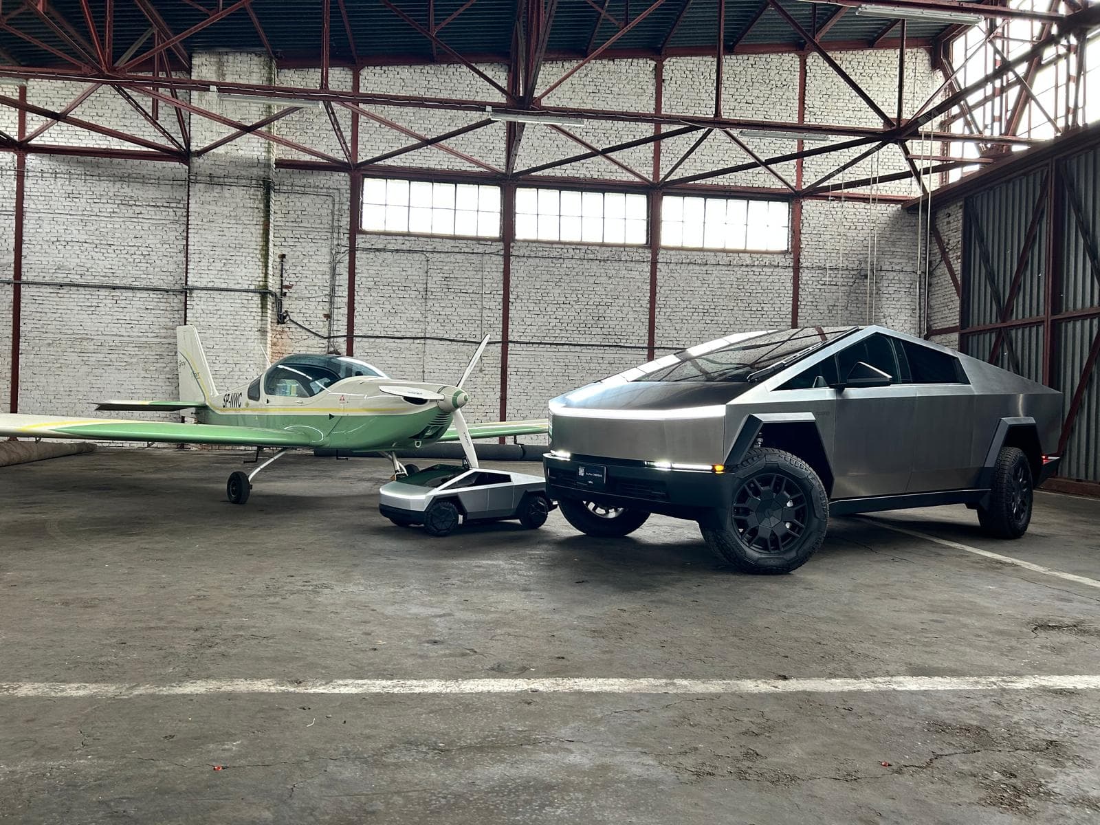 Tesla Cybertruck w hangarze lotniczym obok samolotu